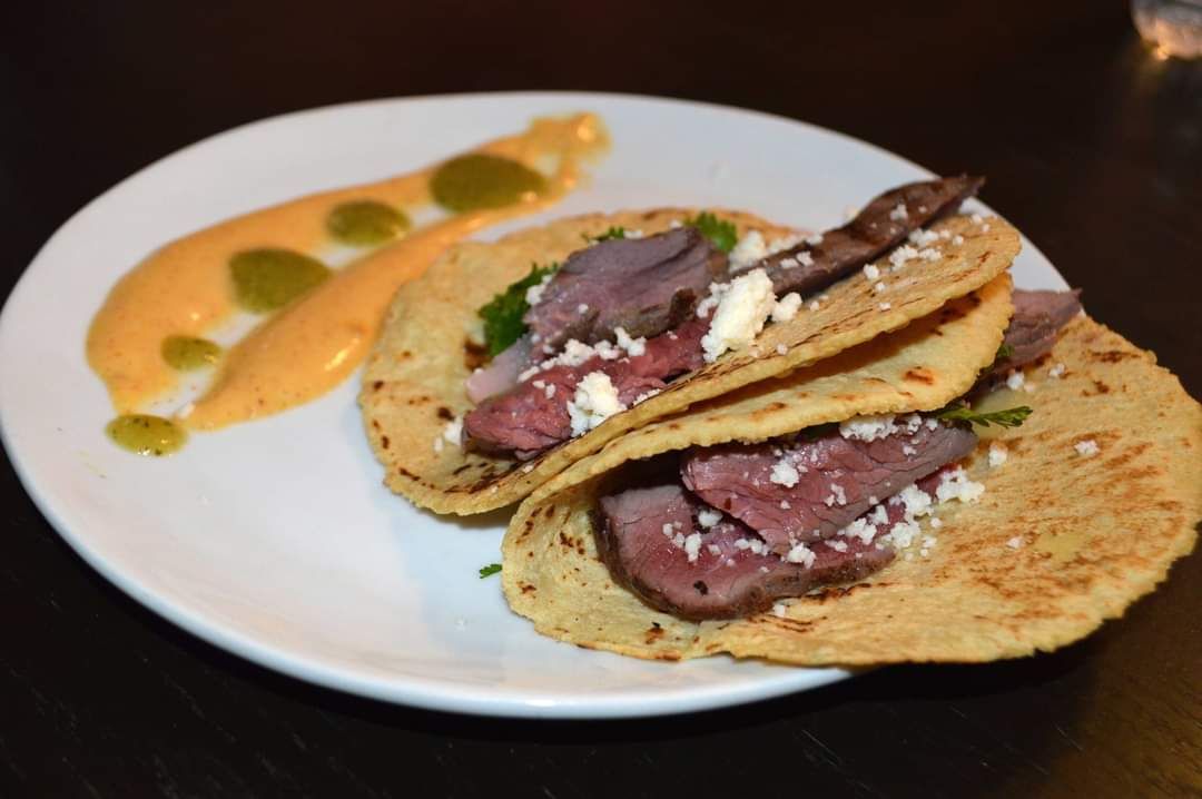 Ostrich tacos, served on corn tortillas, with queso fresco, pickled radish, spicy smoked aioli, and guava salsa verde